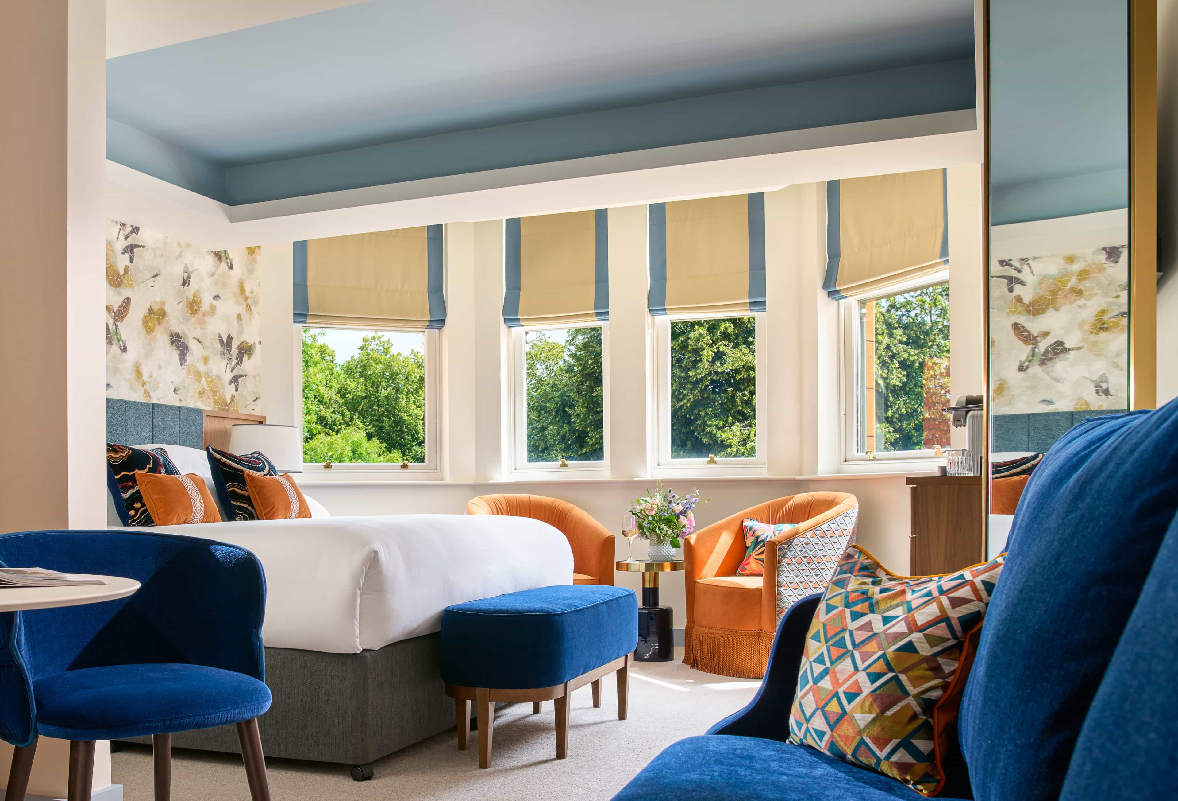 a vibrant hotel room with royal-blue and orange chairs