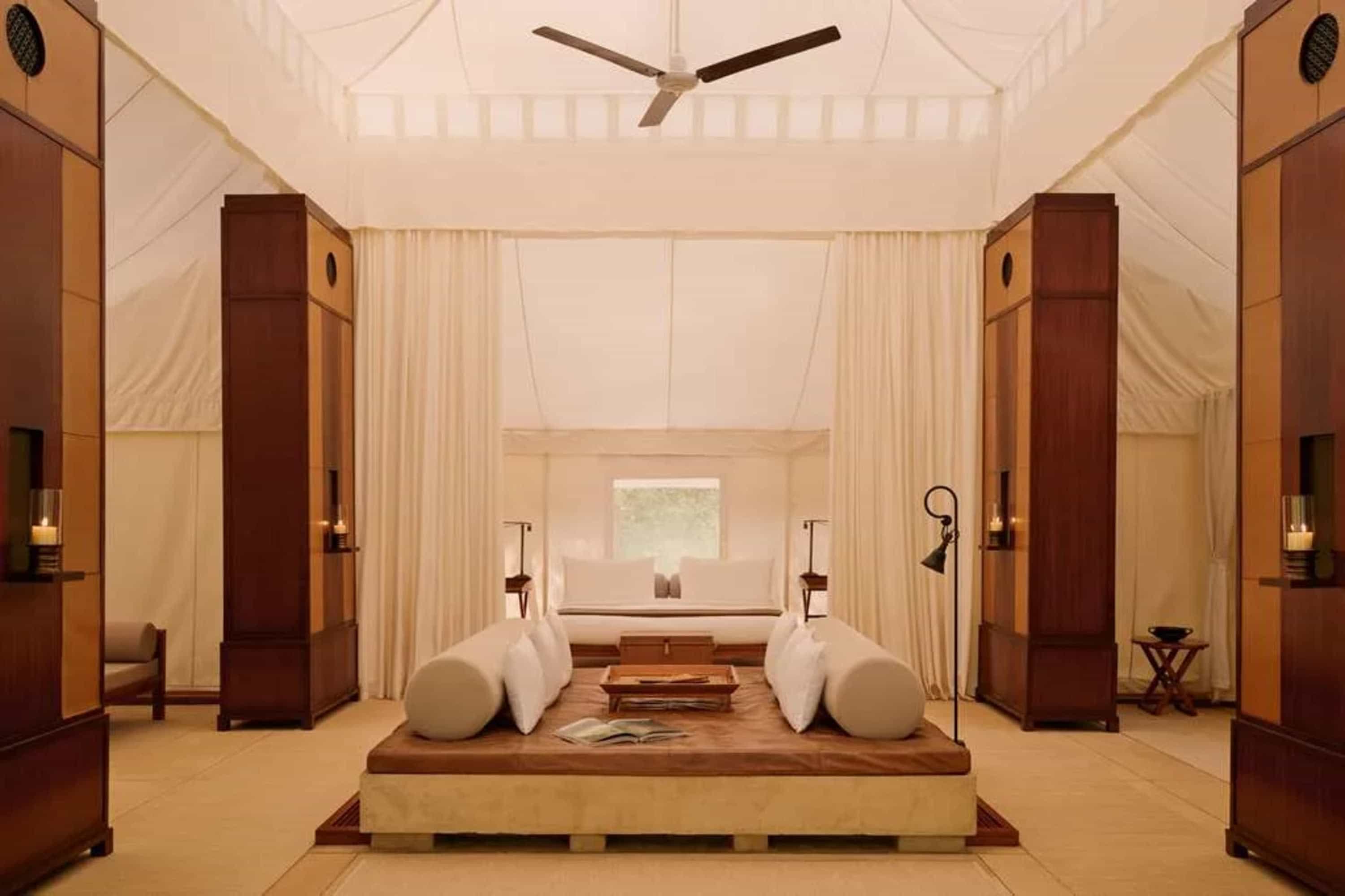 Elegant furnishings under a canvas-walled room with a day bed at the center