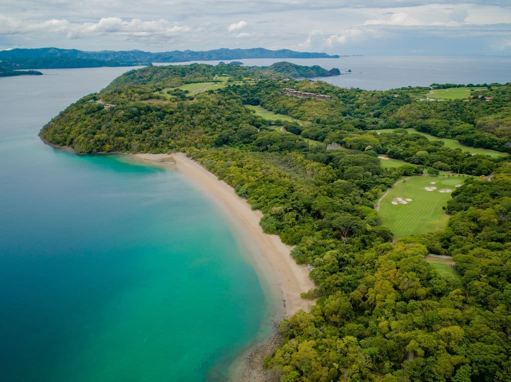 aerial view of green land meeting blue coastline