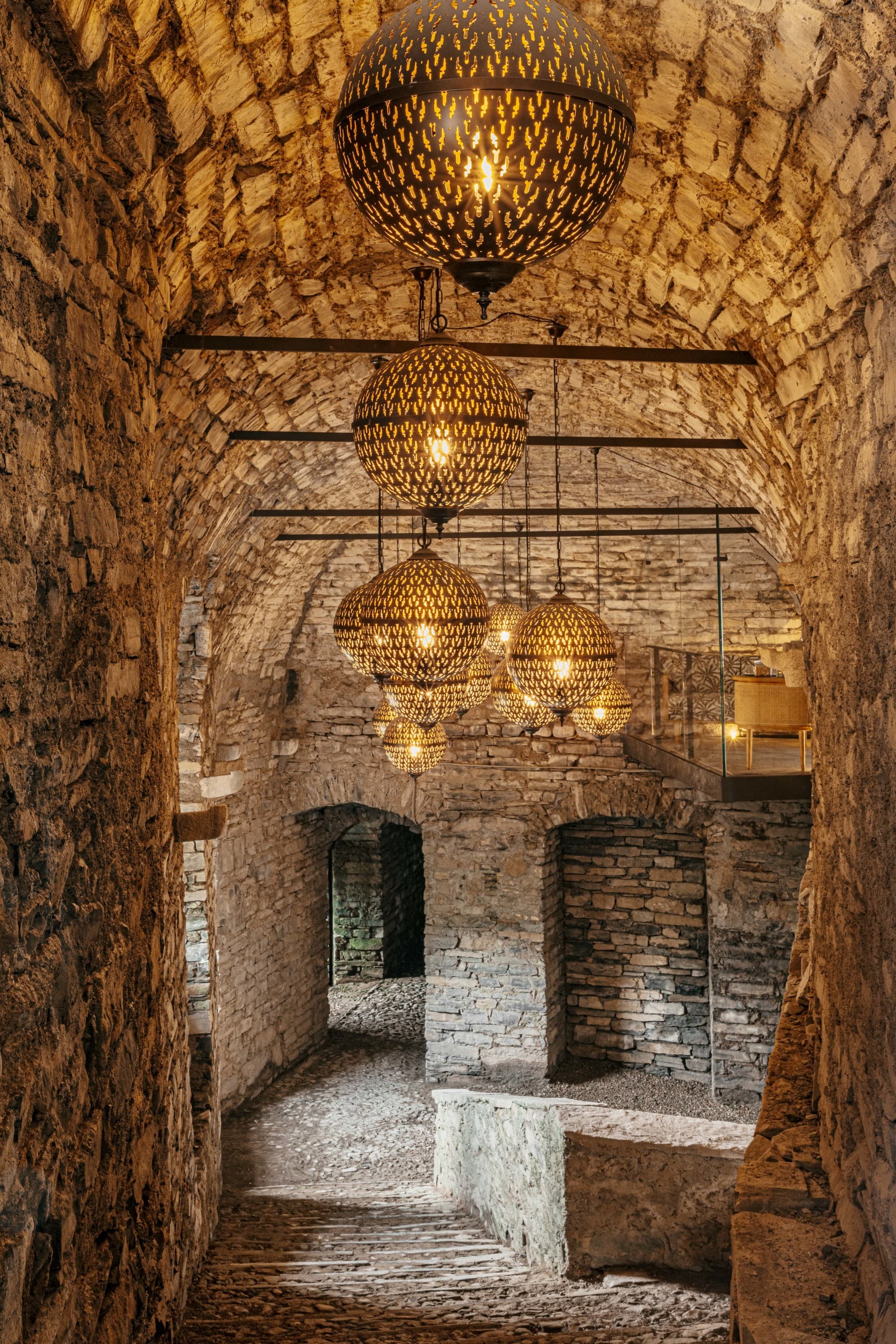 a stone tunnel illuminated by lanterns