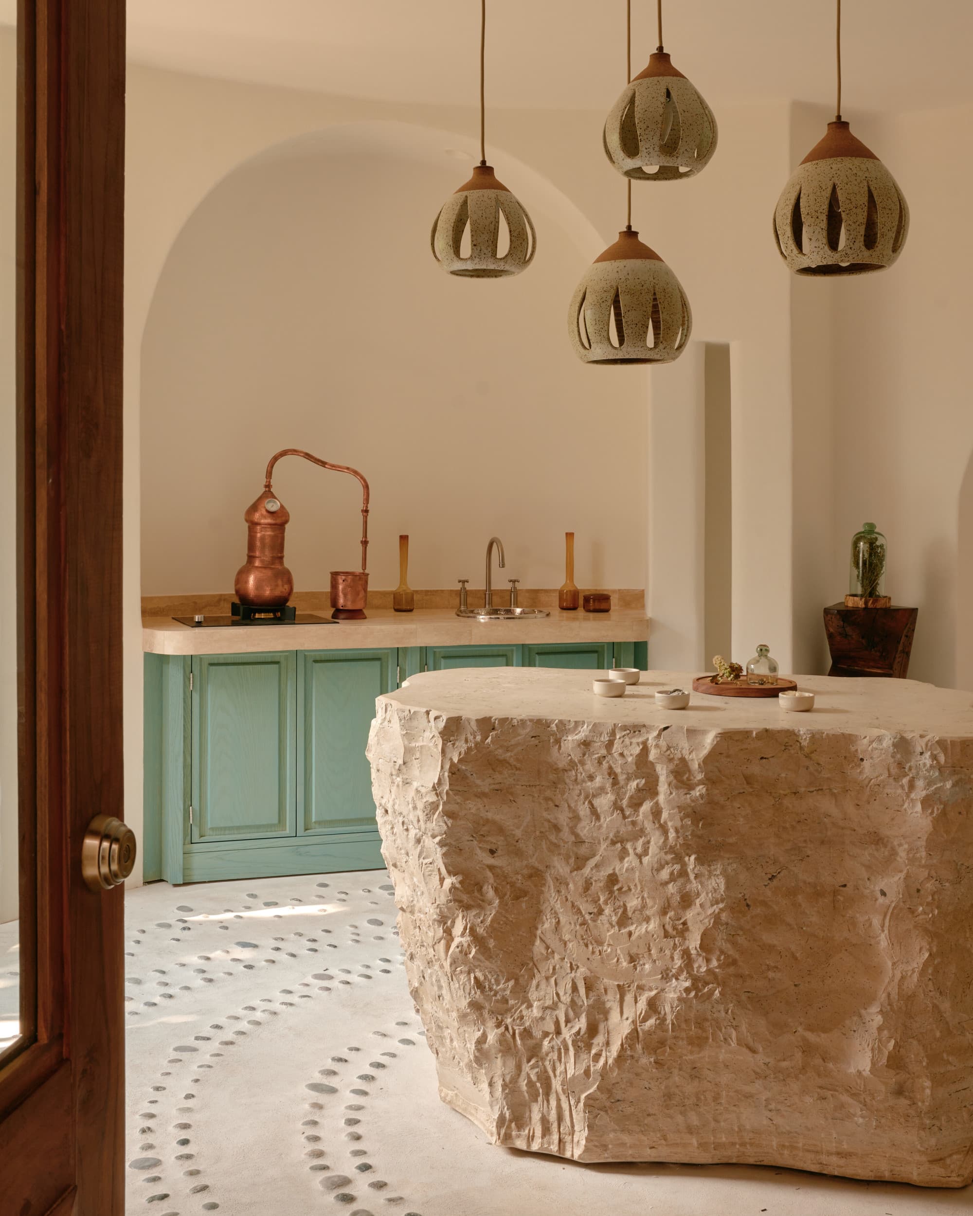 a luxe stone table in a breezy room with hanging lamps