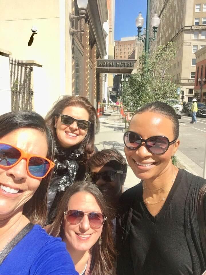 A selfie photo of a group of people outside in a city street