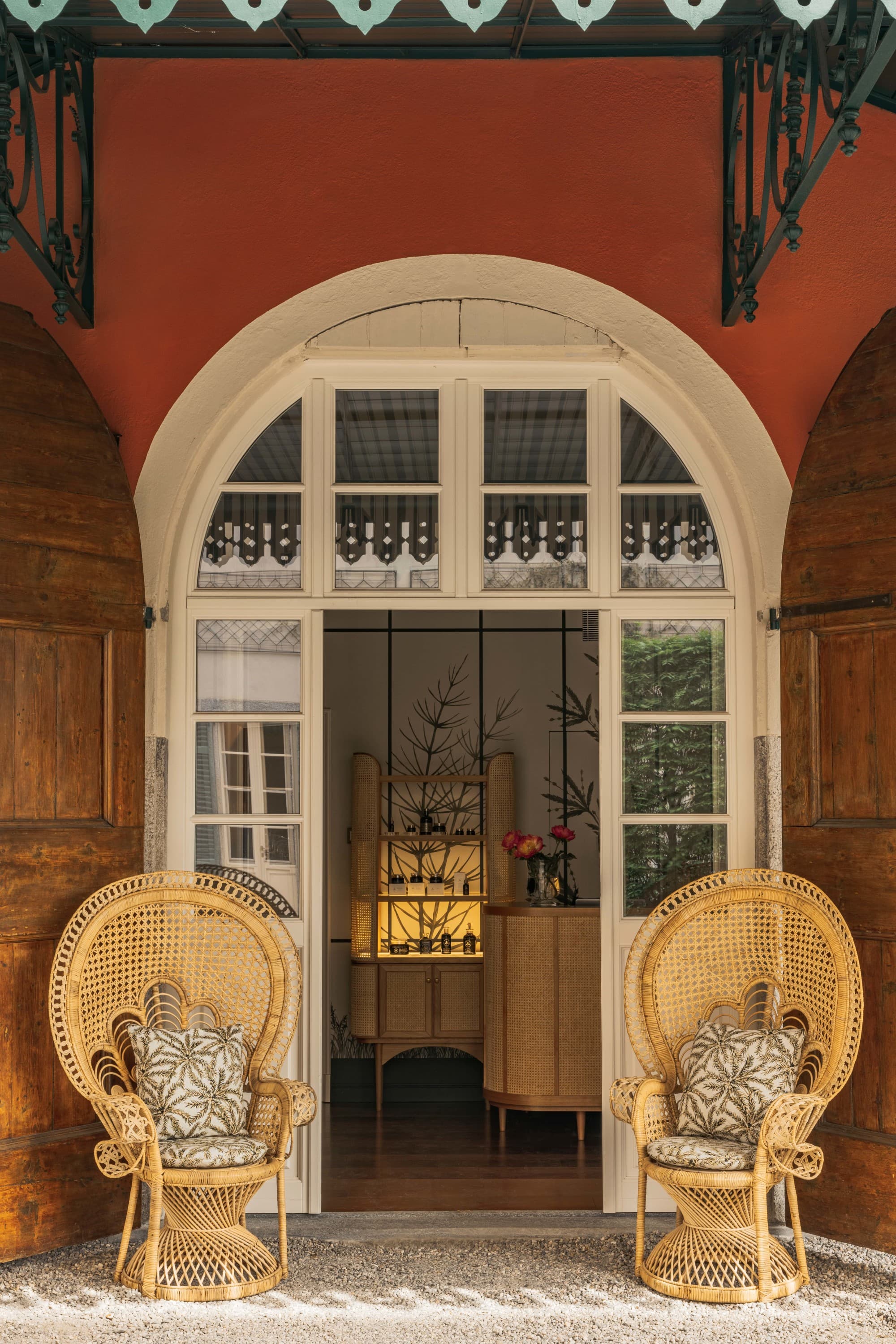 a luxe entrance to a spa flanked by two wicker chairs