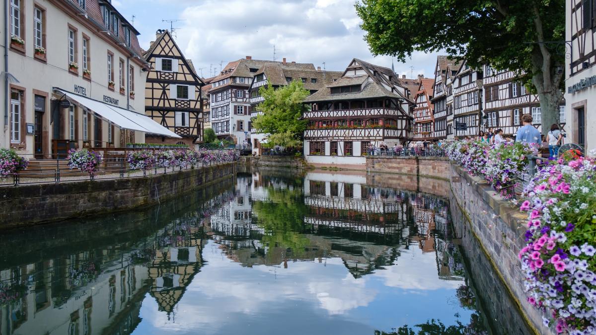 German and French historical buildings next to canal in small French town.
