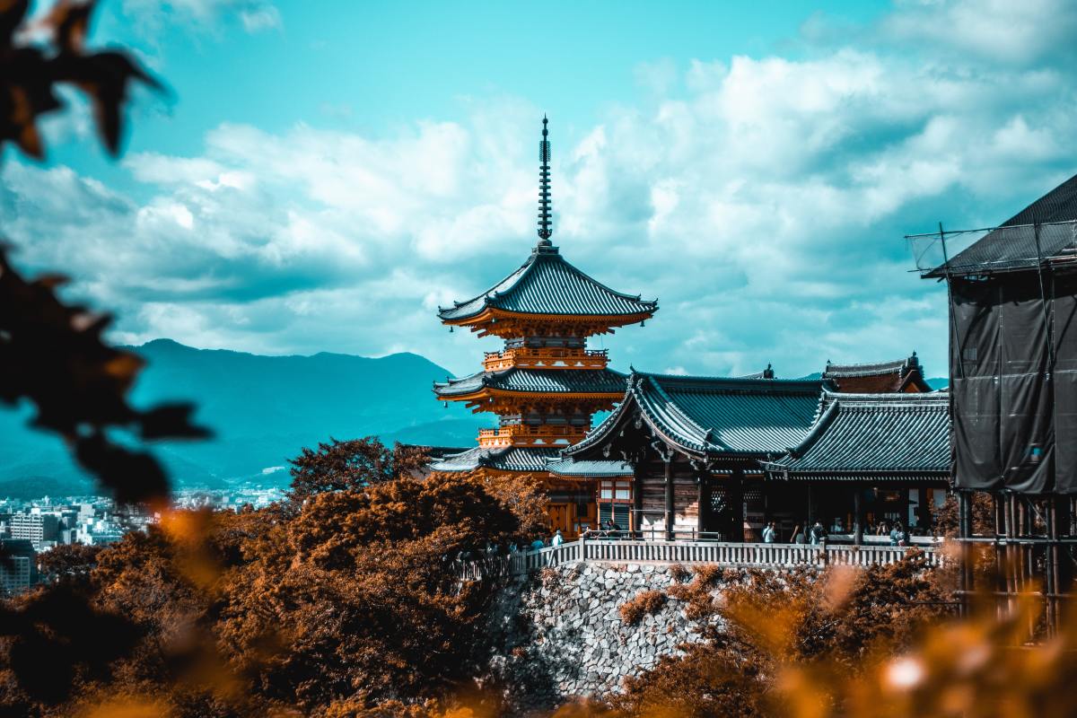 Japanese temple on top of hills in the distance on a sunny day.