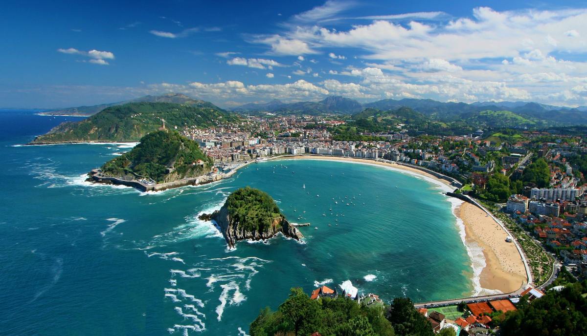 Cove of San Sebastian with deep blue waters and greenery.