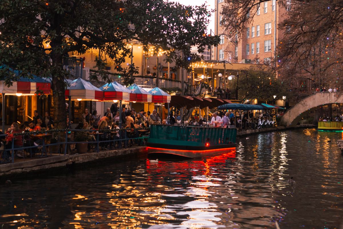 a view of a boat on a river by a restaurant