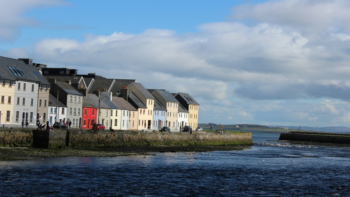 White and brown concrete buildings next to a body of water